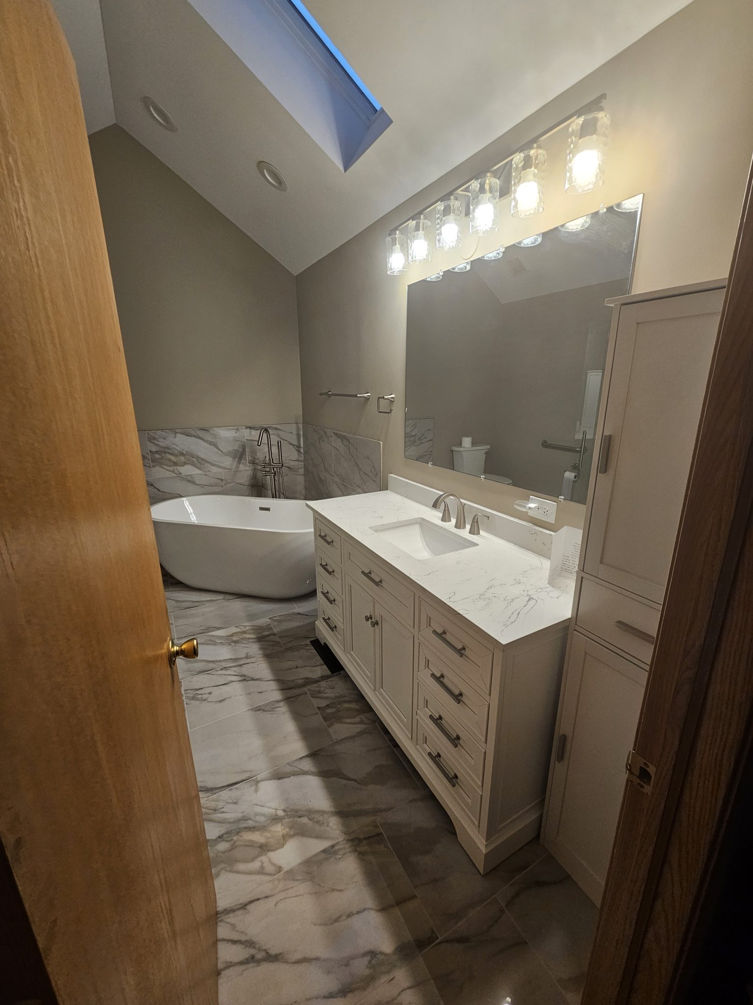 Modern bathroom design featuring a freestanding tub, sleek vanity, and elegant marble flooring by a trusted bathroom remodeling contractor.